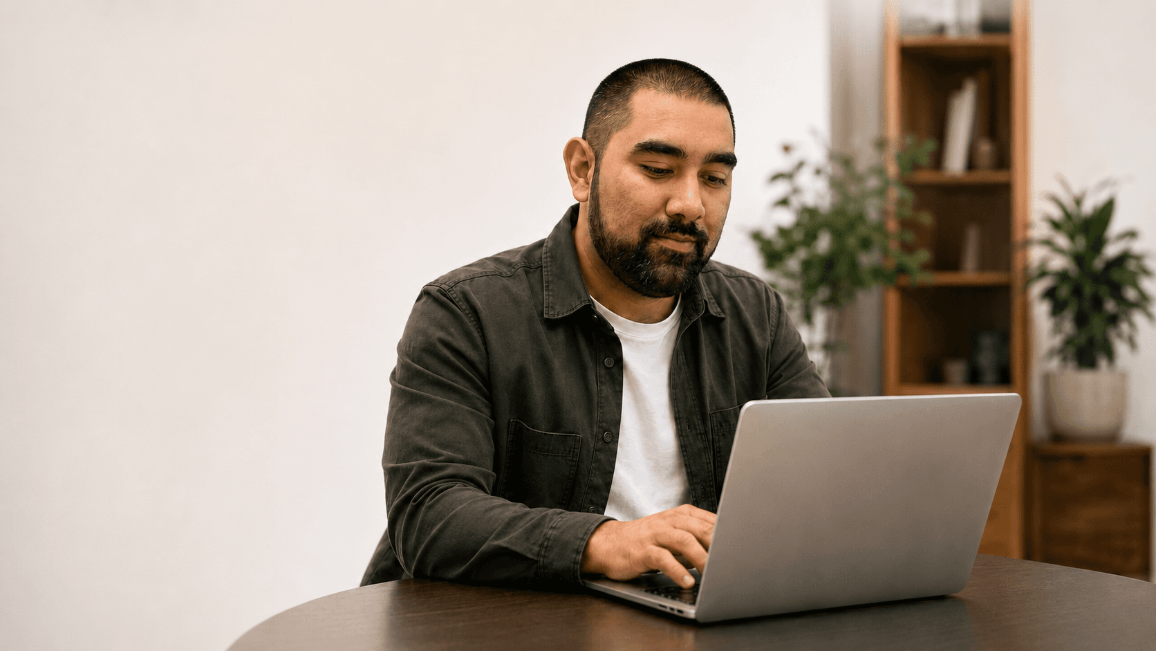 A professional smiling while working at his laptop